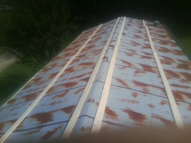 Rusted metal roof panels with new wood purlins before replacement — Storm Damage Roof Repair in Seward by Roofing Brothers